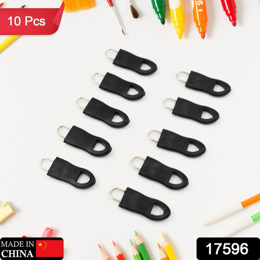 Ten black rubber zipper pull tabs arranged on a white surface surrounded by colorful art supplies.
