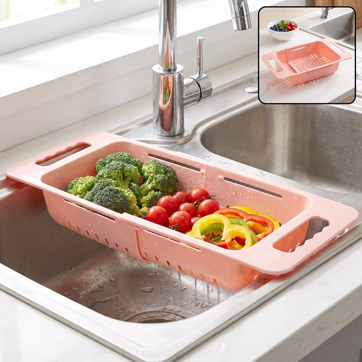 Pink plastic adjustable over-sink drain basket with broccoli, tomatoes, and bell peppers in a kitchen sink.