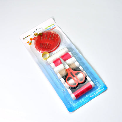 A clear plastic-packaged sewing kit containing thread, a thimble, scissors, and a needle holder.