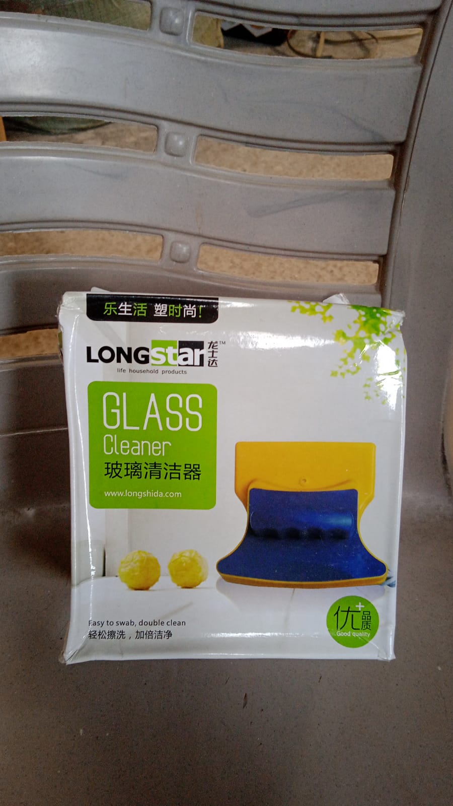 The product's retail packaging, labeled "LONGSTAR GLASS Cleaner," resting on a chair.
