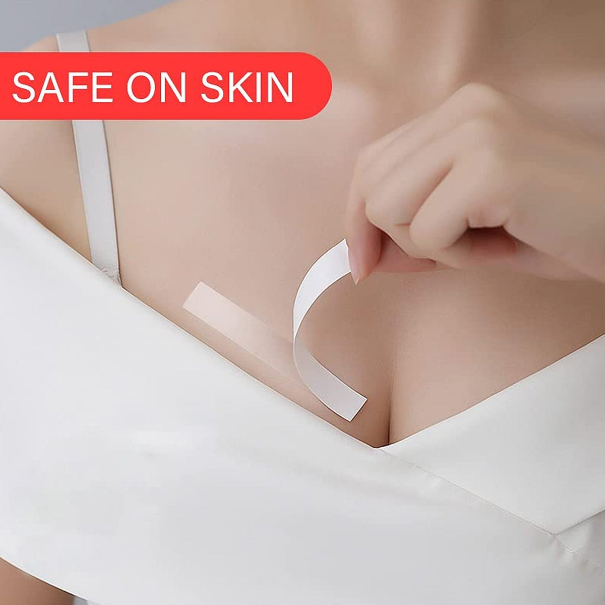 A person applies a clear strip of tape to their chest, securing a white low-cut top.