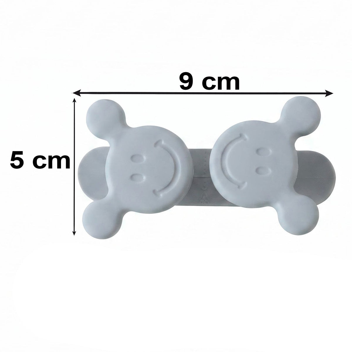 A gray silicone cord organizer with two smiling faces, showing dimensions of 9 cm width and 5 cm height.