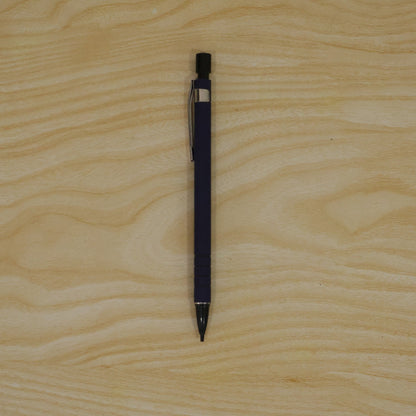 A blue mechanical pencil with a black tip and clip is centered on a light wooden surface.