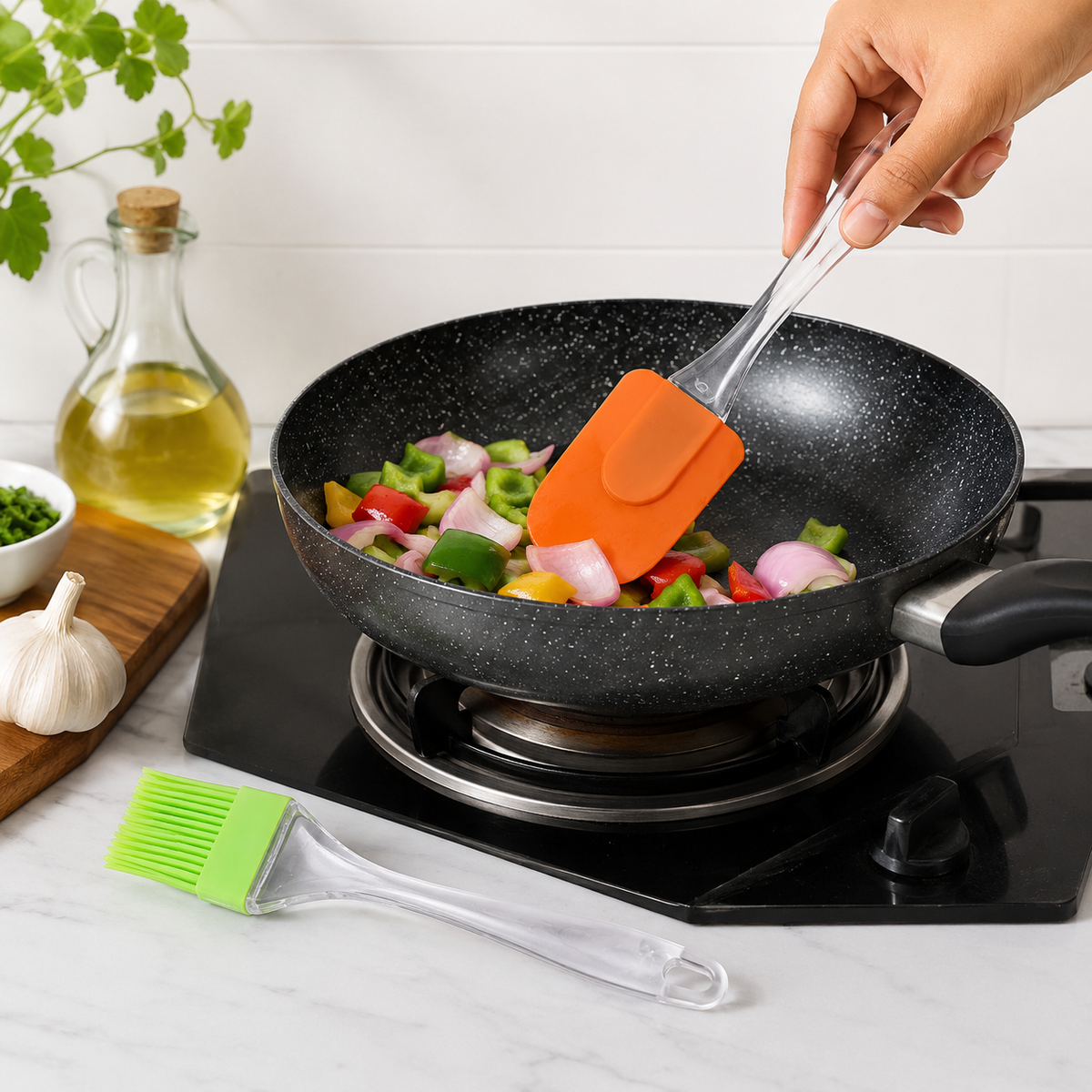 A hand uses an orange silicone spatula to stir chopped vegetables in a black frying pan on a stovetop.