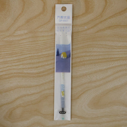 A white and blue pen refill in clear plastic packaging with a cartoon house design, lying on a wooden surface.
