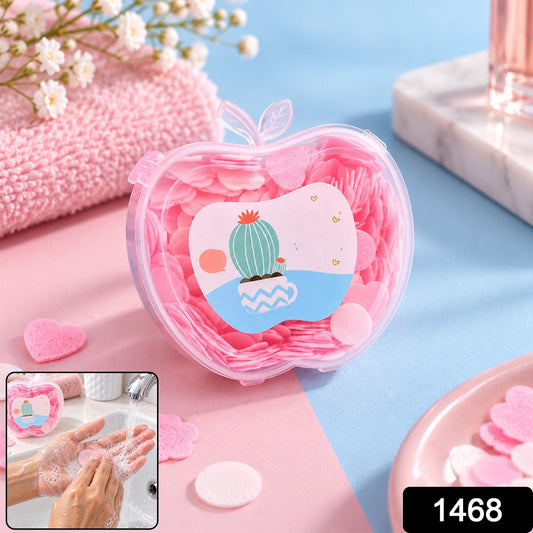 A clear apple-shaped container of pink soap pieces, with a small inset showing hands lathering soap under running water.