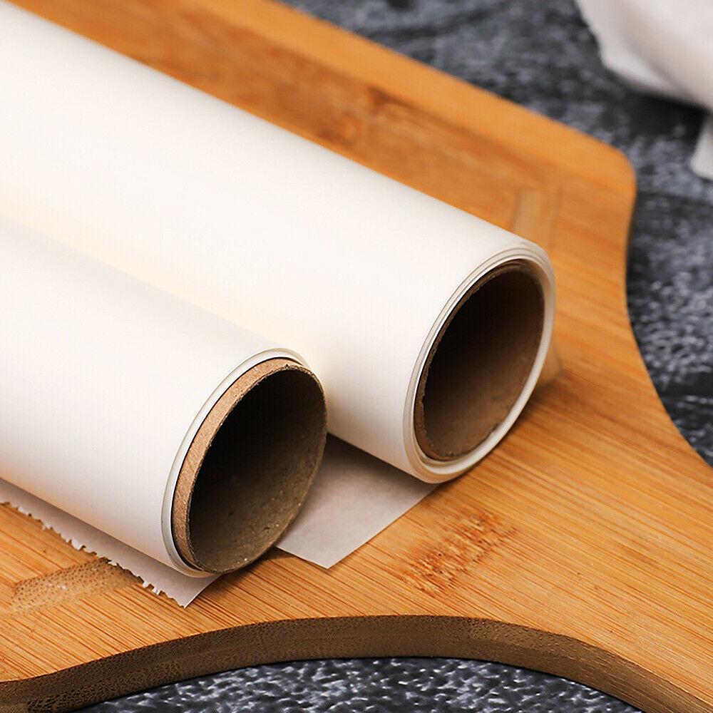 Two rolls of white baking paper with brown cardboard cores on a wooden cutting board.