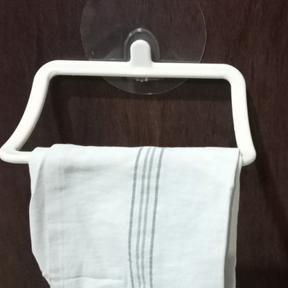 White plastic towel holder with a light gray striped towel, mounted on a dark wooden door.