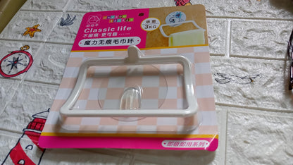 Retail packaging for the white plastic towel holder on a white brick-patterned surface with nautical decorations.