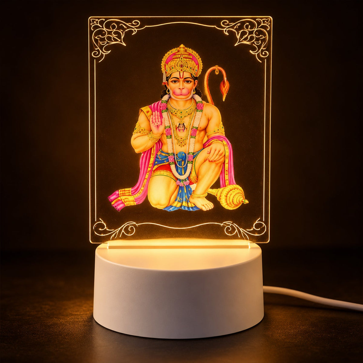 A Hanuman LED acrylic night lamp glowing warmly in a dark room, highlighting the intricate design and light base.