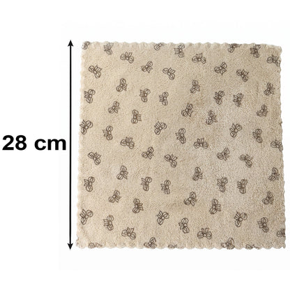 A beige microfiber towel with a dark bow pattern and scalloped edges lies flat on a white background, with a 28 cm